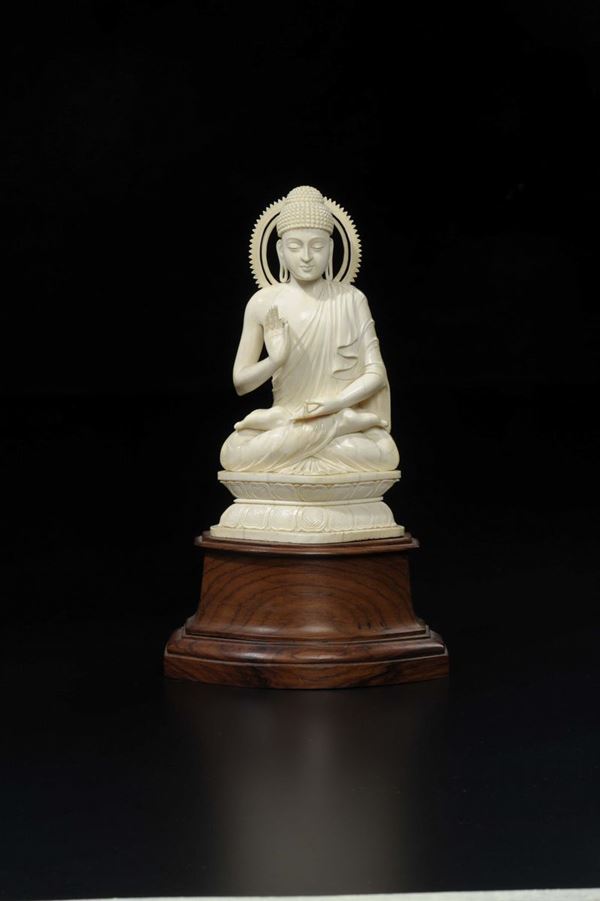 A carved ivory figure of Buddha with aura sitting on a double lotus flower, China, early 20th century