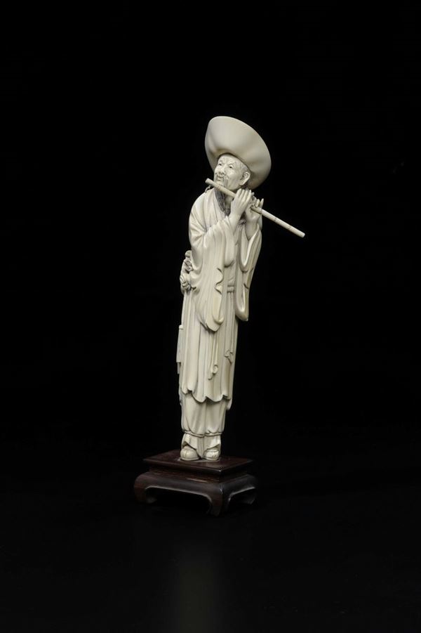 A carved ivory flute player with hat, China, Qing Dynasty, 19th century