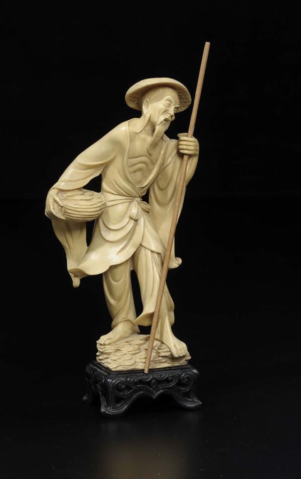 A carved ivory fisher man with stick and basket full of fish, Japan, early 20th century