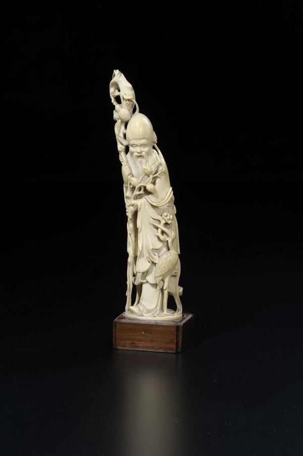 A carved ivory figure of Shoulao with crane and stick with flowering branches, China, early 20th century