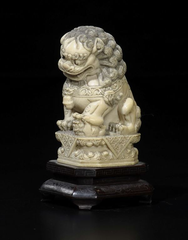 A carved ivory Pho dog on a lotus flower dominating on a smaller dog, China, early 20th century