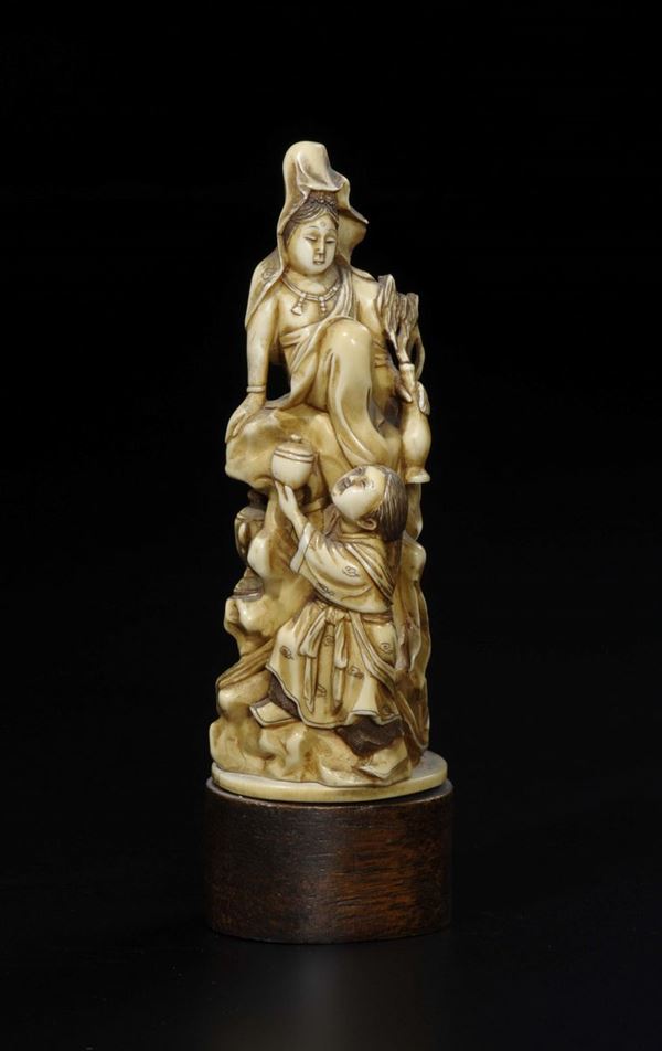 A carved ivory sitting Guanyin and child with vases group, China, Qing Dynasty, late 19th century