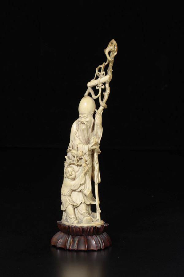 A carved ivory figure of Shoulao with child and stick, China, early 20th century