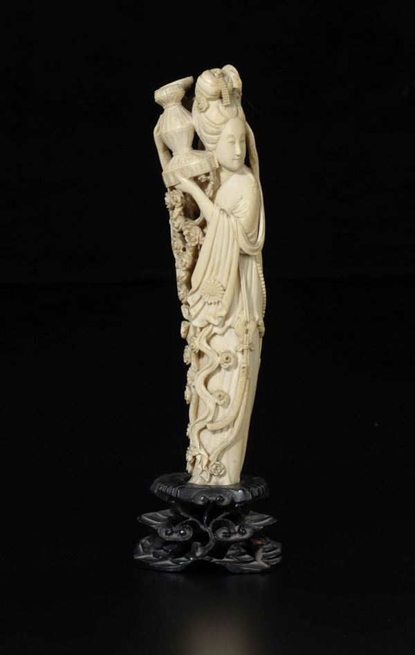 A carved ivory figure of Guanyin with vase and flowering branches in relief, China, early 20th century