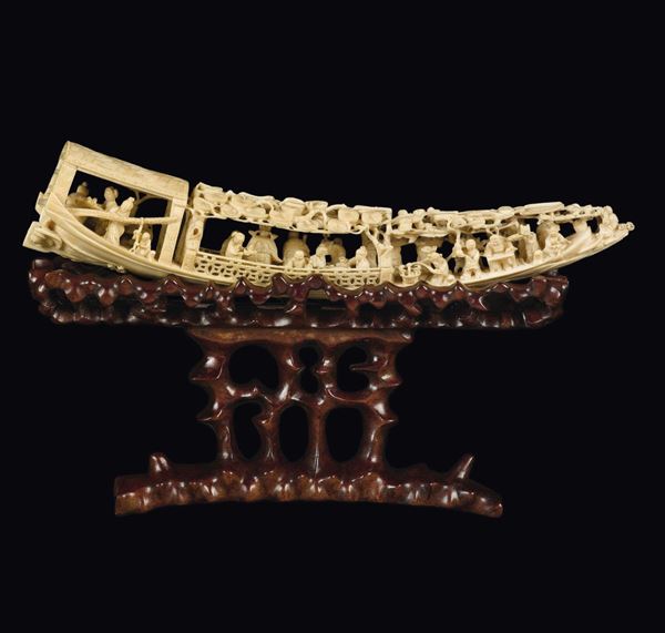A carved ivory boat with figures on a fretworked wooden base, China, early 20th century