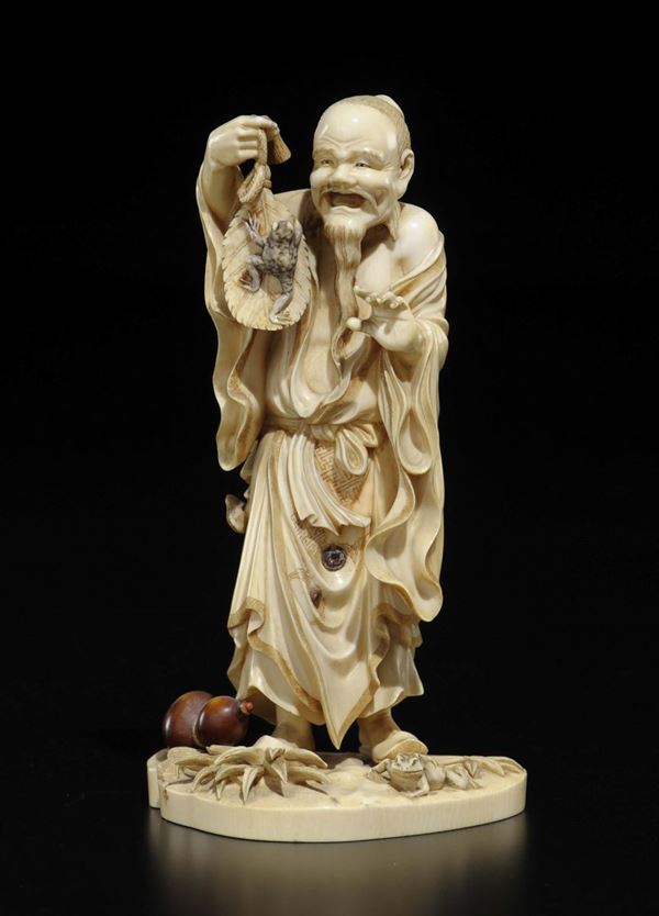 A carved ivory wise man with frog on a leaf group, China, Qing Dynasty, late 19th century