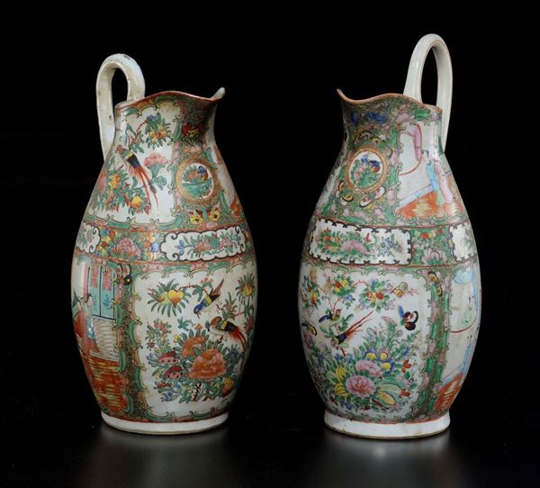 A pair of Canton polychrome enamelled porcelain jugs with figures, birds and flowers within reserve, China, Qing Dynasty, 19th century