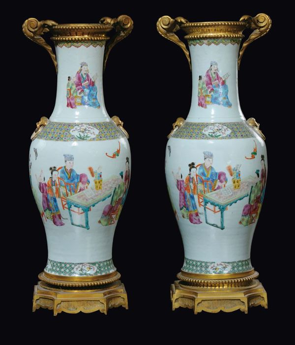 A pair of Famille-Rose vases on gilt bronze bases with common life scenes, China, Qing Dynasty, 19th century