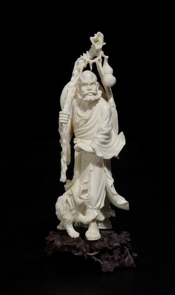 A carved ivory wise man with stick and dog group, China, early 20th century