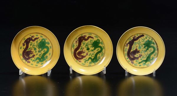 Tre piattini in porcellana a fondo giallo con raffigurazioni di draghi, Cina, Dinastia Qing, XIX seco [..]