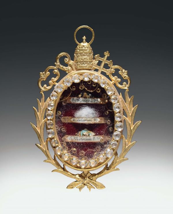 Medaglione porta reliquie in argento dorato sbalzato e traforato con racemi, tiara e chiavi papali. Roma XIX secolo
