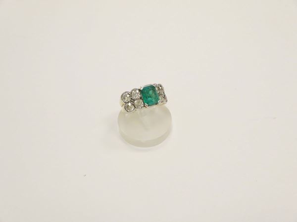 Anello con smeraldo centrale e diamanti a lato