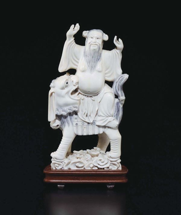 A carved ivory figure of wise man on a Pho dog, China, early 20th century