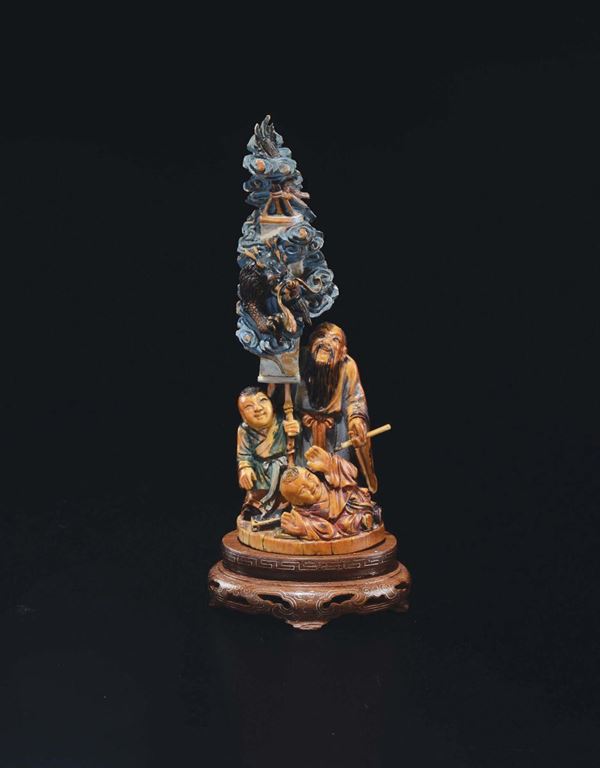 A carved painted ivory wise man and children group, China, early 20th century