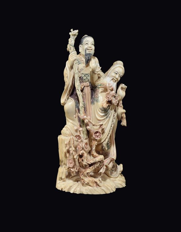 A carved painted ivory two wise men with branches of roses group, China, early 20th century