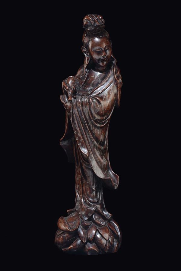 A carved wood figure of Guanyin with silver-metal inlays, China, Qing Dynasty, 19th century