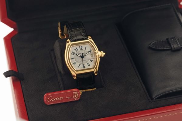 CARTIER REF. 2524 ROADSTER YELLOW GOLD Cartier, Roadster, Automatic, case No. 850699CD, Ref. 2524. Made circa 2000. Fine, tonneau-shaped, curved, center seconds, self-winding, water resistant to 100 m, 18K yellow gold wristwatch with date and a quick change leather strap with an 18K yellow gold Cartier deployant clasp. Accompanied by Certificate, box, additional straps and instruction booklet.