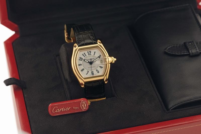 CARTIER REF. 2524 ROADSTER YELLOW GOLD Cartier, Roadster, Automatic, case No. 850699CD, Ref. 2524. Made circa 2000. Fine, tonneau-shaped, curved, center seconds, self-winding, water resistant to 100 m, 18K yellow gold wristwatch with date and a quick change leather strap with an 18K yellow gold Cartier deployant clasp. Accompanied by Certificate, box, additional straps and instruction booklet.  - Auction Watches and Pocket Watches - Cambi Casa d'Aste