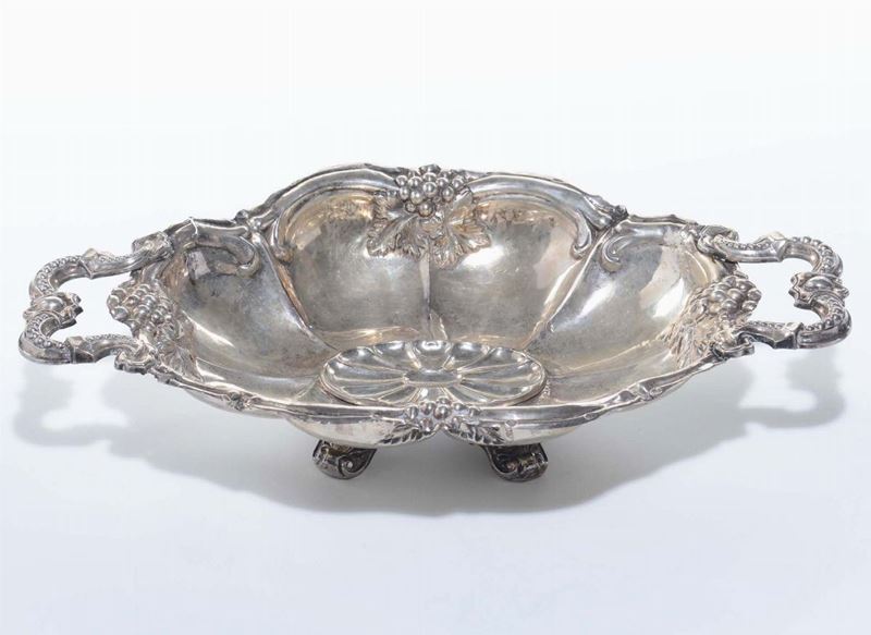 Centrotavola ovale biansato in argento sbalzato, XIX secolo  - Auction Furnishings from the mansions of the Ercole Marelli heirs and other property - Cambi Casa d'Aste