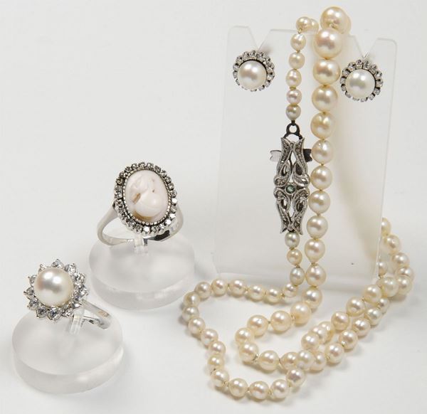 Lotto composto da una collana di perle scalari, un anello con perla e diamanti, un anello con cammeo e diamanti ed un paio di orecchini