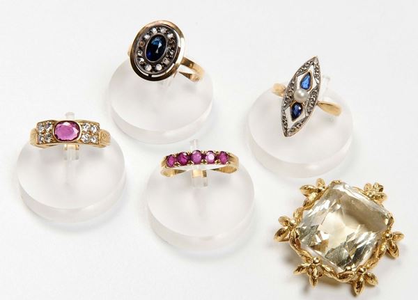 Lotto composto da quattro anelli ed un pendente montati con zaffiri, rubini e quarzo