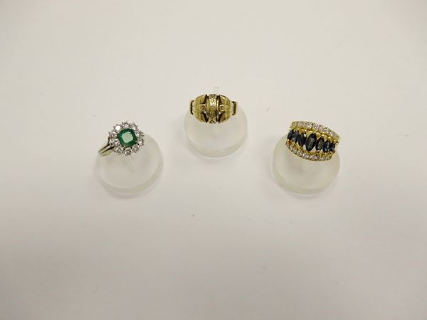 Lotto composto da tre anelli con diamanti, zaffiri e smeraldo