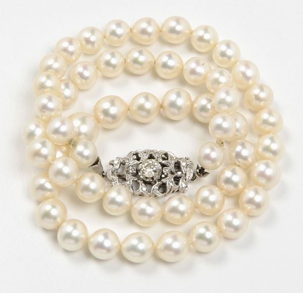 A cultured pearl necklace with a diamond and gold clasp