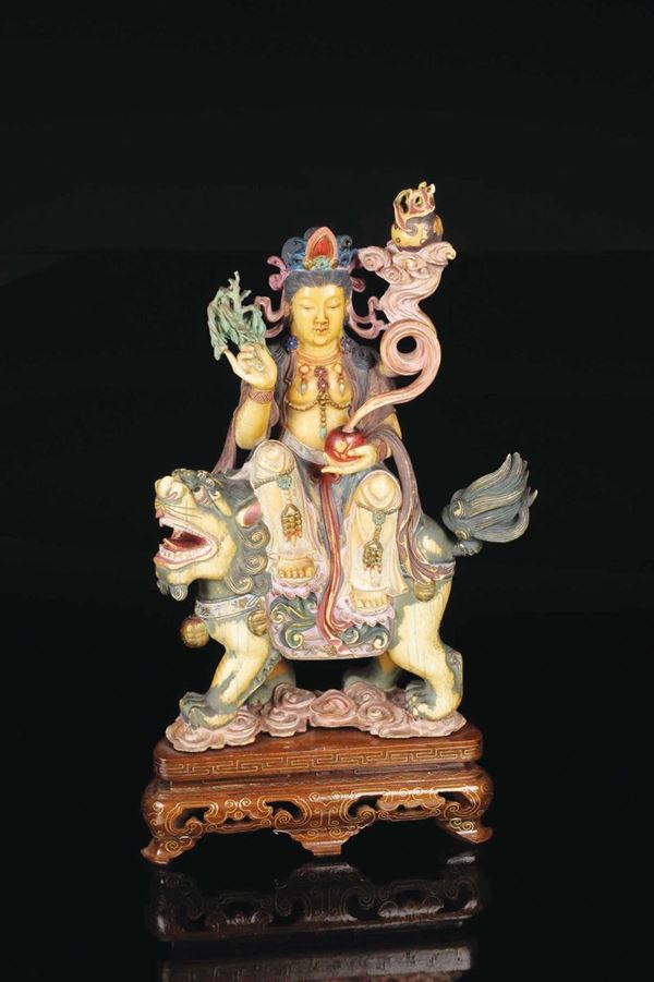 A carved and painted ivory Guanyin on Pho dog group, China, early 20th century