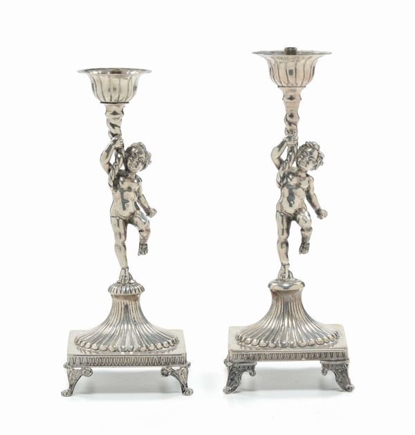 Coppia di candelieri in argento a forma di puttini, XIX secolo