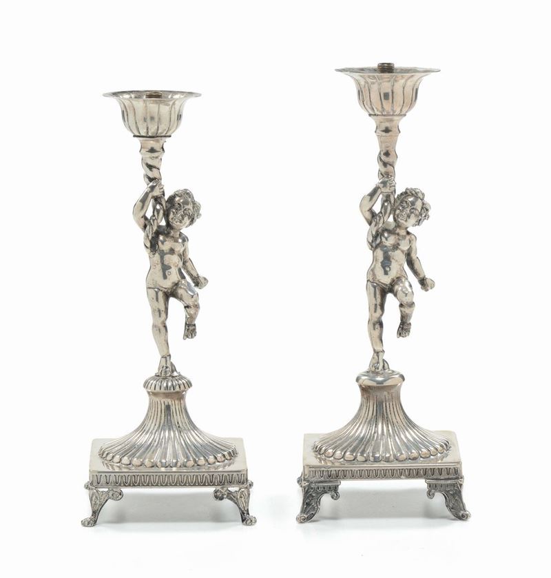 Coppia di candelieri in argento a forma di puttini, XIX secolo  - Asta Arredi dalle dimore degli eredi Ercole Marelli e altre provenienze - Cambi Casa d'Aste