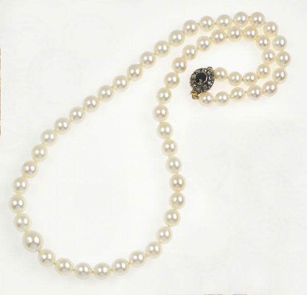 A cultured pearl necklace with diamond and sapphire clasp