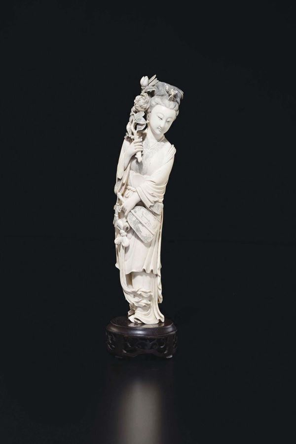 A carved ivory figure of Guanyin with roses, China, Qing Dynasty, 19th century