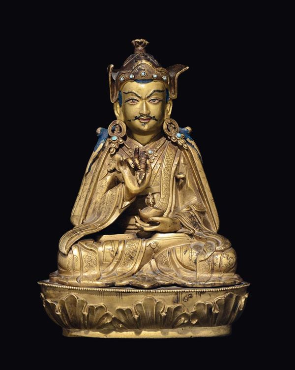 A gilt bronze figure of Padmasambhava with cup and vajra, Tibet, 17th century