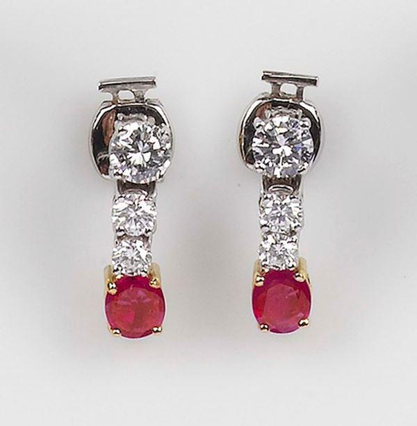 A ruby and diamond earrings. The Burma rubies and round brilliant-cut diamonds are mounted in yellow and white gold 750/1000