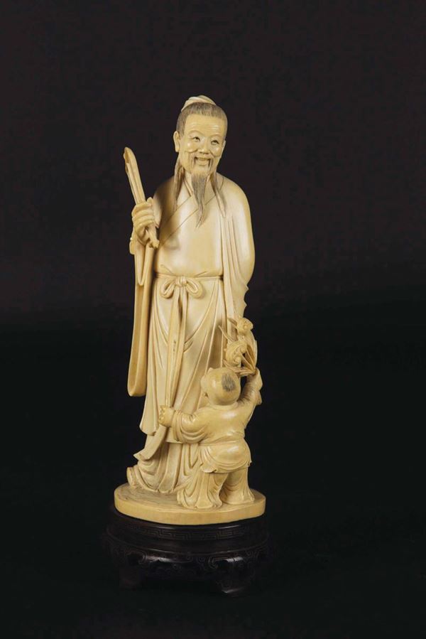 A carved ivory wise man with fan and child group, China, early 20th century