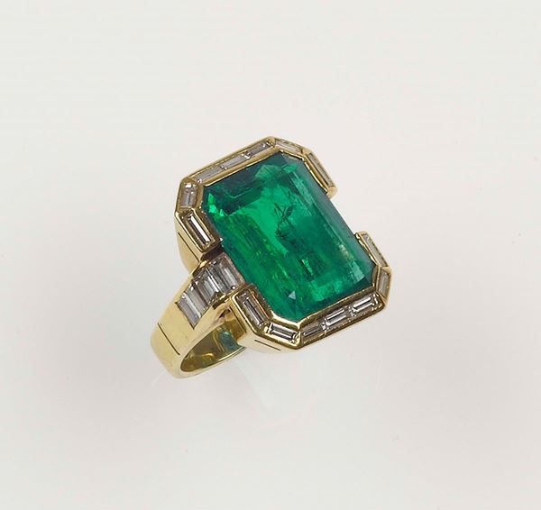 A Colobmbian emerald weighing approx. 18,50 carats. Set with baguette-cut diamonds and mounted on a ring