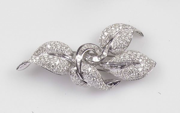 A diamond brooch. The round brilliant-cut and tepper- cut diamonds