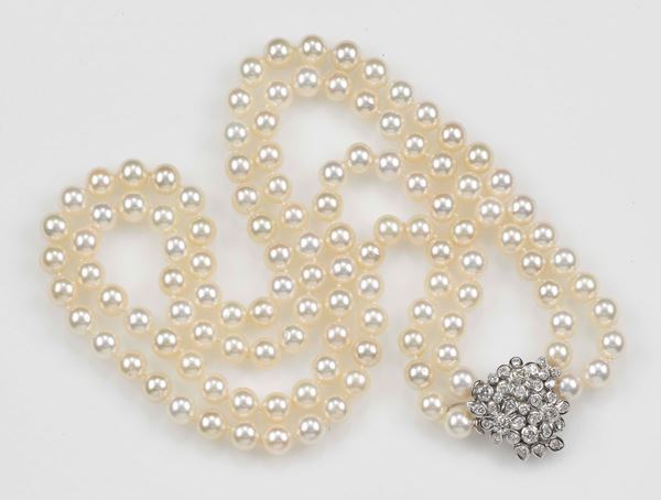 A two-row Akoya pearl necklace. The clasp is set with diamonds and mounted in white gold 750/1000