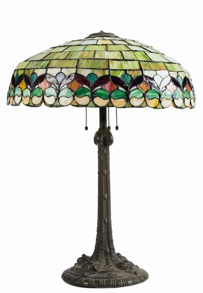 Manifattura americana, Lampada da tavolo in metallo cesellato e vetro al piombo a decoro geometri...
