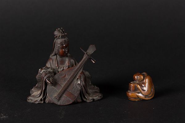 A lot of two carved wood figures, a playing Geisha and a small sleeping wise man, Japan, Meiji Period, 19th century