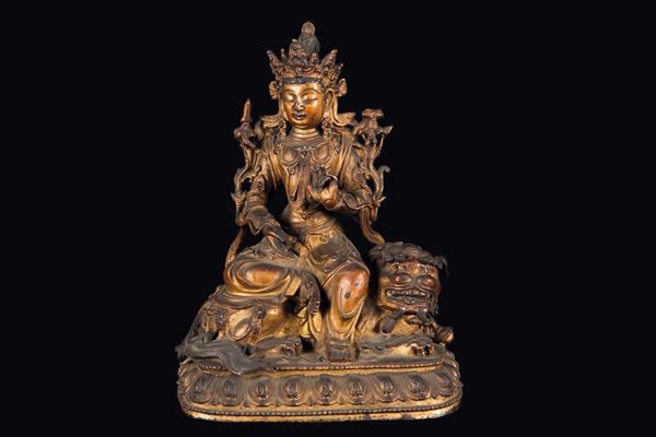 A semi-gilt bronze figure of Simhanada-Avalokitesvara seated on a Pho dog, China, Ming Dynasty, 17th century