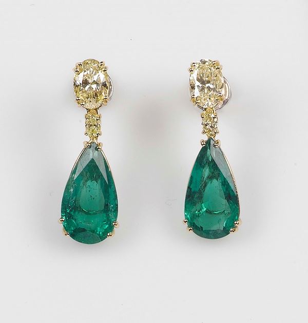 A emerald and diamond earrings. The drop-cut emeralds and diamonds are mounted in yellow gold 750/1000