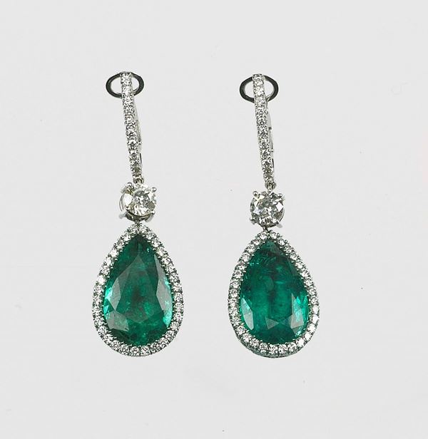 A diamond and drop-cut emerald earrigs. Mounted in titan