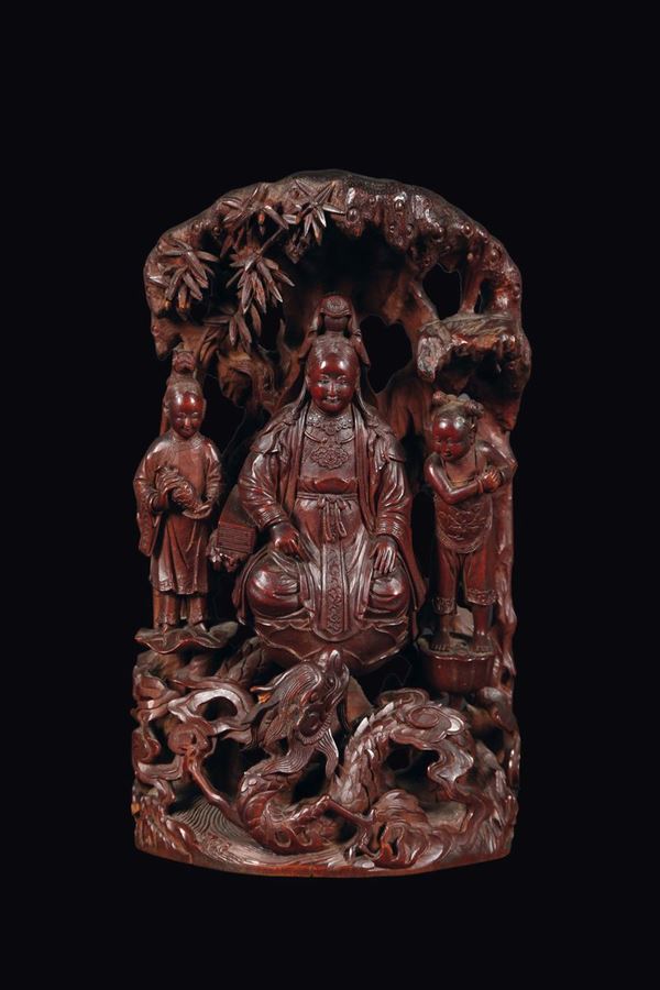 A rare carved wood deity and children group, China, Qing Dynasty, 19th century