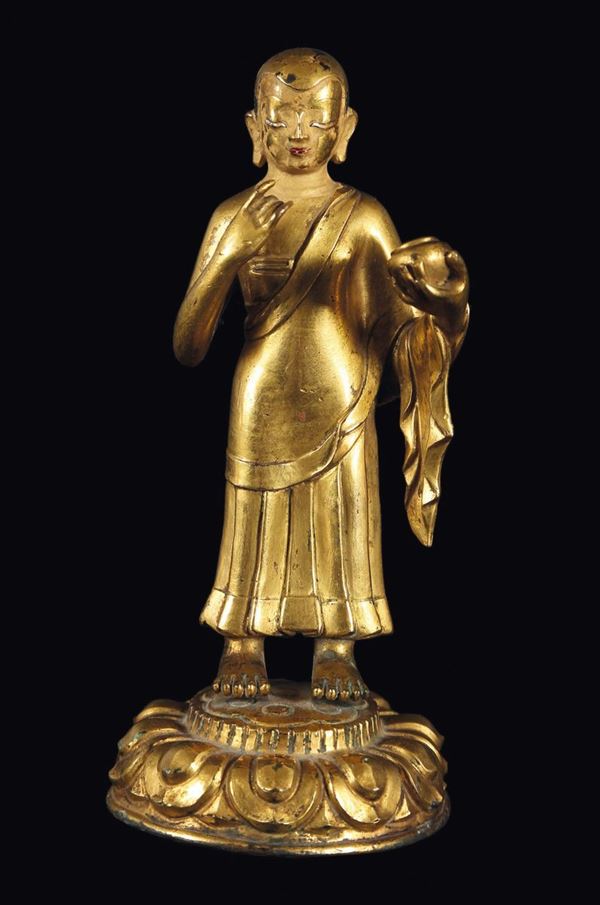 Figura di monaco in bronzo dorato eretto su fiore di loto con coppa, Tibet, XVIII secolo