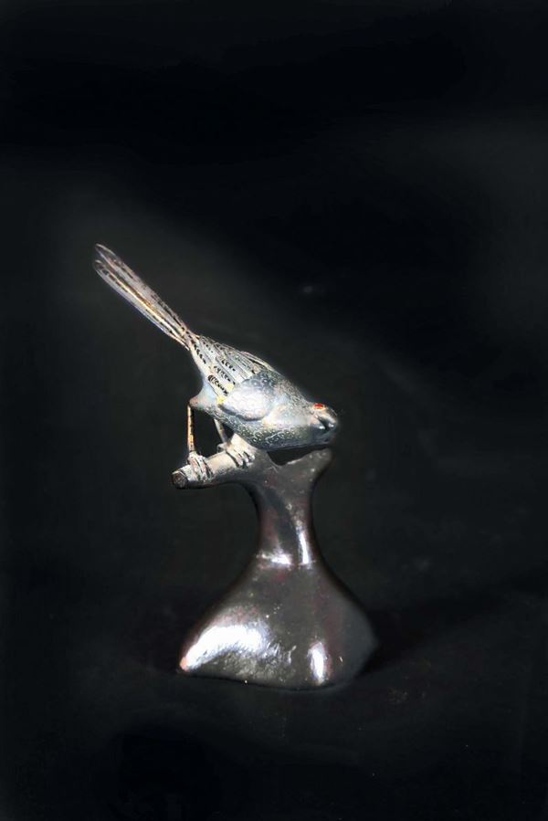 A small metal bird on a wooden stand, China, 20th century