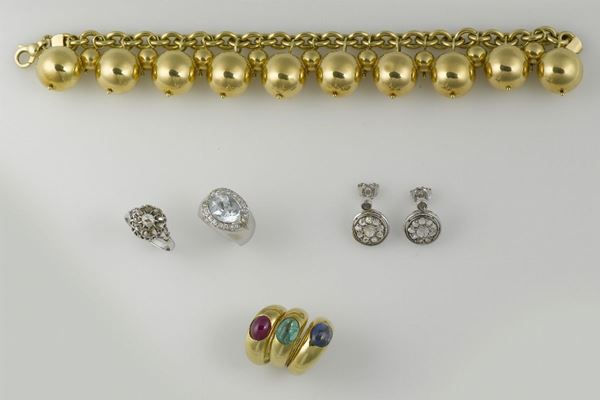 Lotto composto da bracciale, tre anelli con pietre cabochon, un anello con topazio azzurro ed una parure con rosette di diamanti