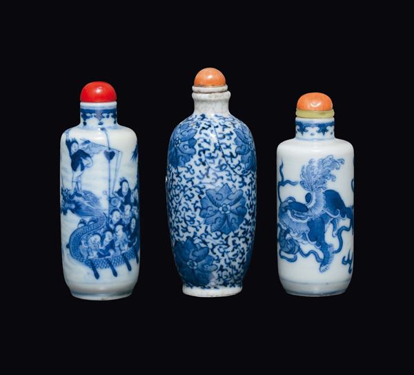 Lotto di tre snuff bottles in porcellana bianca e blu, una con pescatori, una con fiori ed una con cani di Pho, Cina, Dinastia Qing, XIX secolo