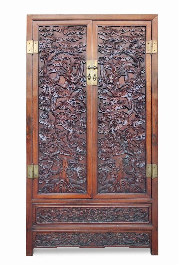 A huanghuali and softwood compound cabinet with finely carved panels with dragons between rocks and clouds, China, Qing Dynasty, 19th century
