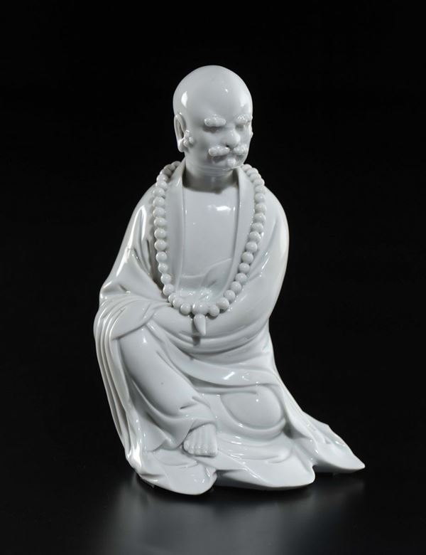 Figura di dignitario seduto in porcellana Blanc de Chine Dehua con baffi e collana da preghiera, Cina, Dinastia Qing, XVIII secolo